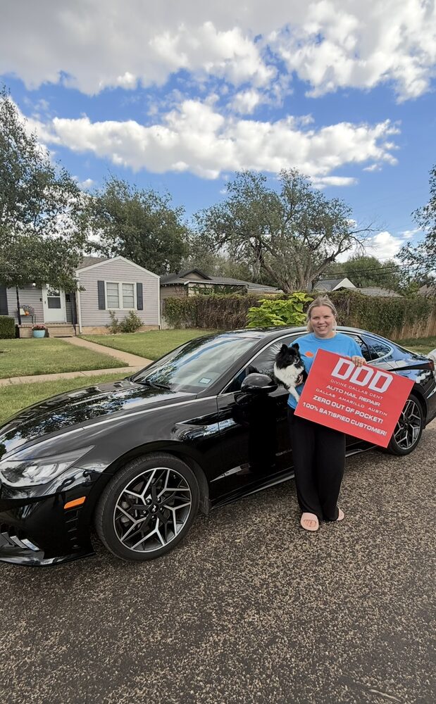 Customer and her dog beside a repaired black Genesis sedan
